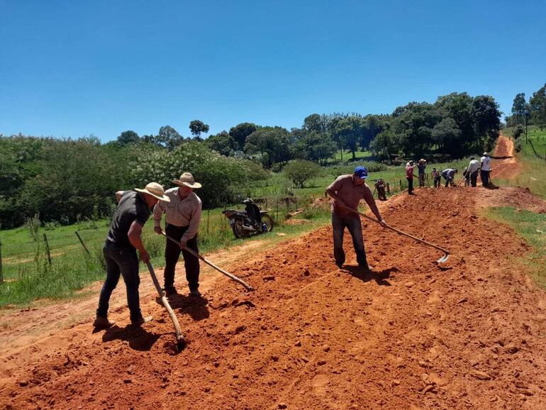 Los pobladores de Kuarahy Rese de San Juan Nepomuceno reparando el camino vecinal con azadas.