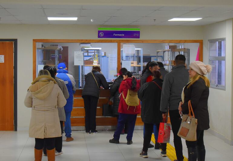 Los asegurados formando fila para retirar medicamentos de la farmacia del IPS.