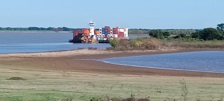 Un remolcador estacionado en la costa del río Paraguay en Pilar esperando que una embarcación pequeña realice los sondeos de profundidad del río para seguir viaje agua arriba.