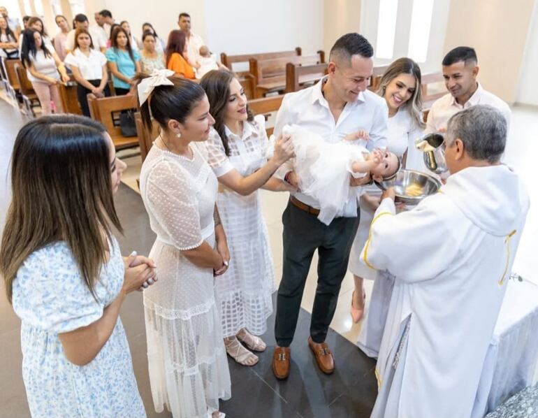 Kerly recibiendo las aguas bautismales ante las tiernas miradas de sus papis y padrinos. (Captura de la historia de Instagram de Karimi Chávez)