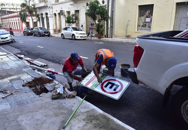 Dos trabajadores colocan una señal de Parxin con las indicaciones para el estacionamiento tarifado. La chef Eugenia Aquino mostró mucha preocupación por el elevado costo que representa el estacionamiento tarifado en Asunción.