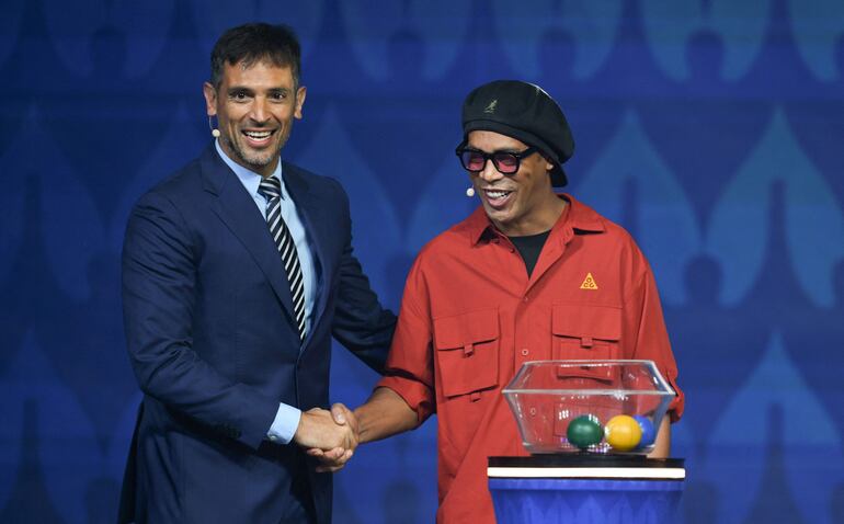 El paraguayo Roque Santa Cruz (i), jugador de Libertad, saluda al brasileño Ronaldinho antes del sorteo de la Copa América 2024. 