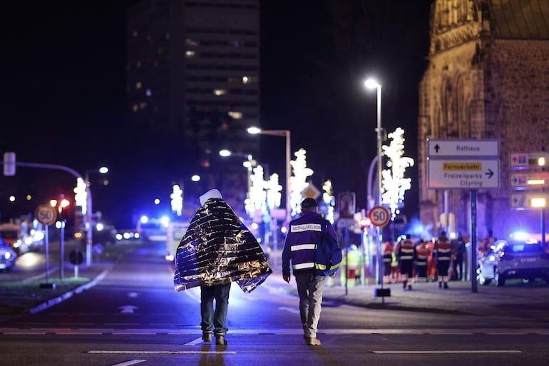 Rescatistas caminan por la calle después de que un automóvil se estrellara contra una multitud en un mercado navideño, hiriendo a más de 60 personas en Magdeburgo, al este de Alemania.