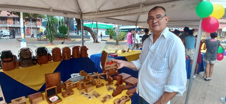 señor posando con una pieza de madera hecha a mano