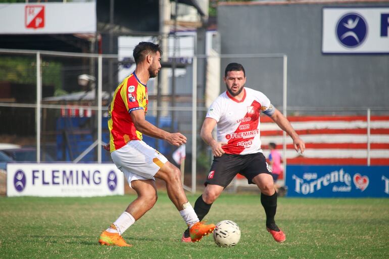 El lateral aurirrojo, Nelson Riquelme extiende el pase ante la presencia de Ernesto "Pinti" Álvarez. (Foto: APF)