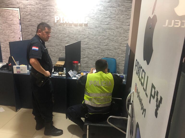 Los policías cuando recababan datos del asalto en la tienda afectada.