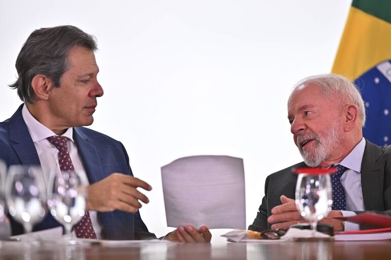 El presidente de Brasil, Luiz Inácio Lula da Silva (d), habla con su ministro de Hacienda, Fernando Haddad.