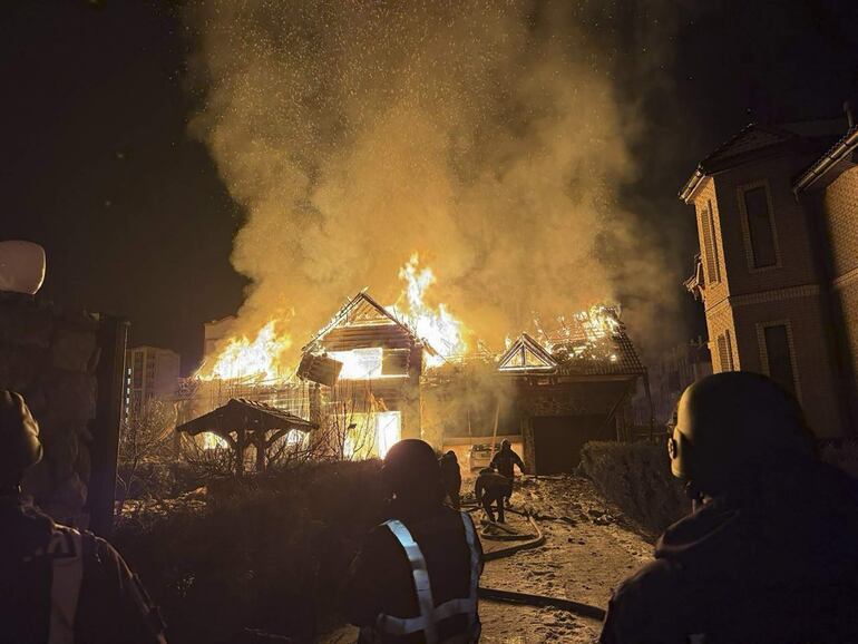 Bomberos ucranianos trabajan en el sitio de uno de los ataques rusos, ayer martes.