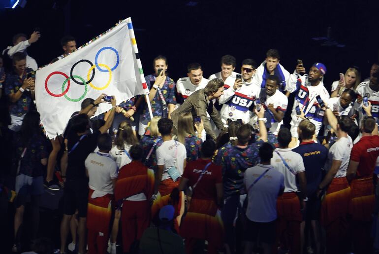 El actor estadounidense Tom Cruise con la bandera olímpica durante la ceremonia de clausura de los Juegos Olímpicos de París 2024 celebrada este domingo, en el Estadio de Francia en Saint-Denis (Francia)