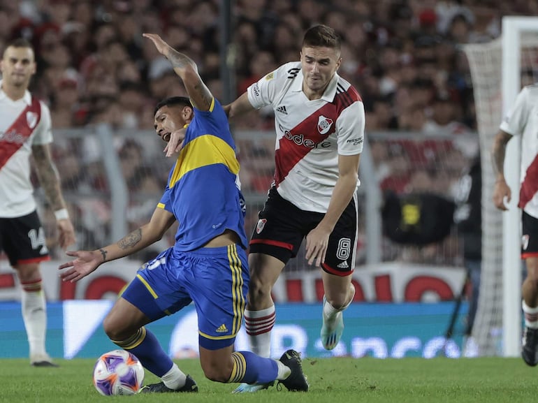 Agustín Palavecino (d), jugador de River Plate, disputa el balón con Ezequiel Fernández, futbolista de Boca Juniors, durante el superclásico del fútbol argentino en el estadio Monumental, en Buenos Aires, Argentina.