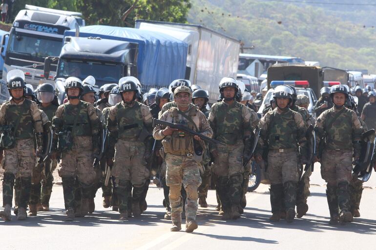 Integrantes de la Policía Militar caminan para intervenir una vía bloqueada, en Mainara (Bolivia).