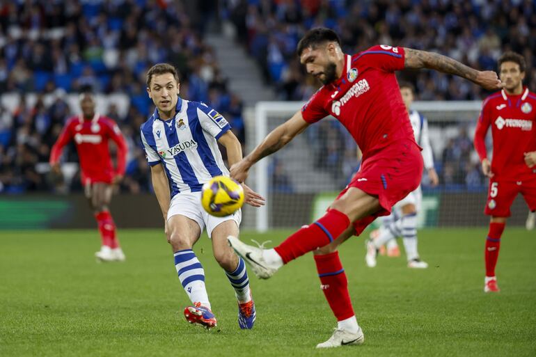 El centrocampista de la Real Sociedad Jon Ander Olasagasti y el defensa del Getafe Omar Alderete, durante el partido de la jornada 21 de LaLiga, este domingo en el estadio Reale Arena en San Sebastián.