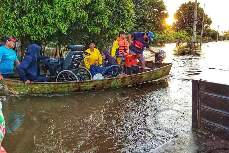 Las familias son rescatadas de sus casas anegadas por la crecida del río Tebicuarymí y reubicadas en albergues habilitados en Coronel Martínez, Guairá.