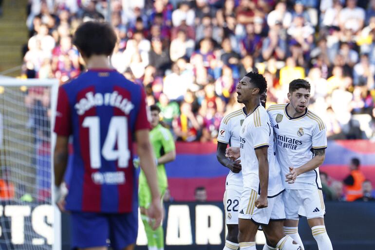 El delantero inglés del Real Madrid Jude Bellingham (2d) celebra su gol junto a sus compañeros durante el partido de LaLiga que enfrenta al FC Barcelona y al Real Madrid este sábado en el Estadio Olímpico Lluís Companys de Barcelona.