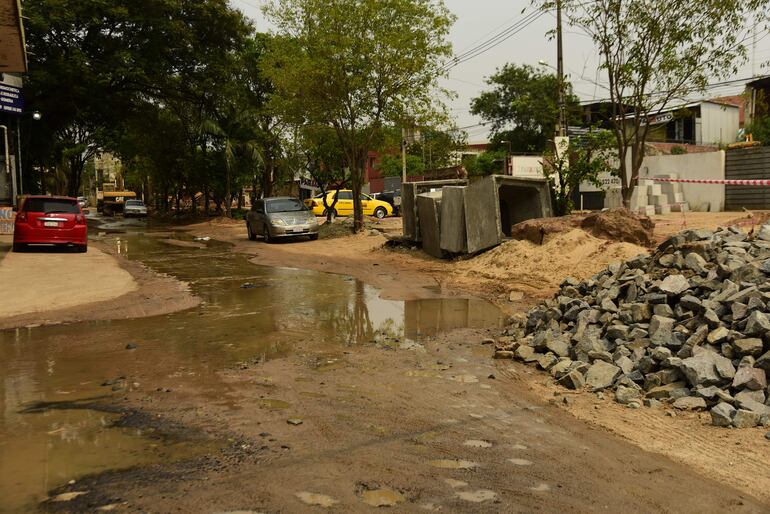 Por este espacio pasan conductores y peatones, entre agua que sale de la obra y materiales de construcción. De noche podría ser un peligro para quienes circulen.