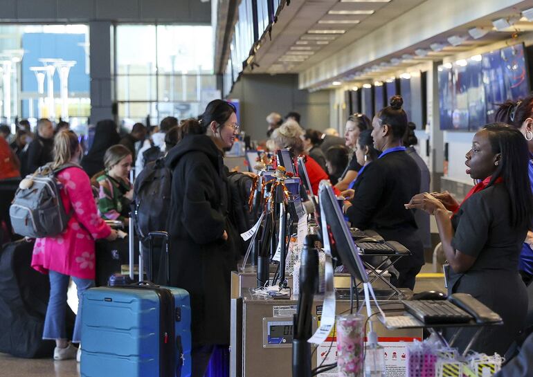 Pasajeros hacen cola para facturar su equipaje y reciben pases de embarque en el Aeropuerto Internacional Austin-Bergstrom, en Austin, Texas, EEUU.