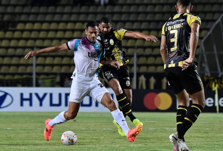 Roque Santa Cruz cubre el balón ante la marca del defensor del Táchira Carlos Robles.