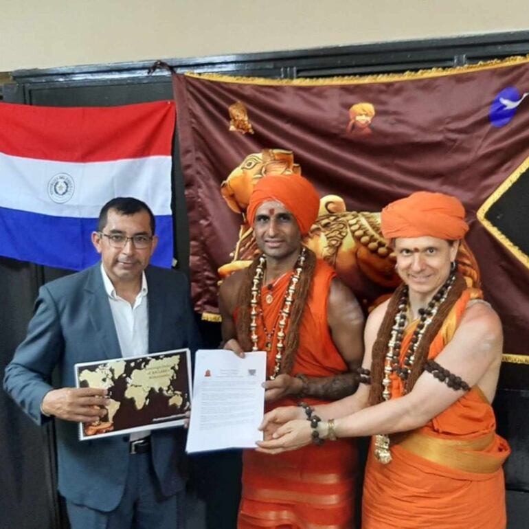 Luis Carlos Pereira, intendente de María Antonia, Paraguarí, firmando la proclamación con los representantes de los Estados Unidos de Kailasa.