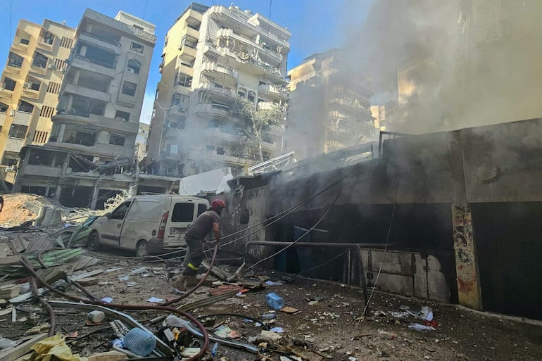 Un bombero trabaja en el sitio de un bombardeo israelí en un suburbio del sur de Beirut, Líbano, este domingo.