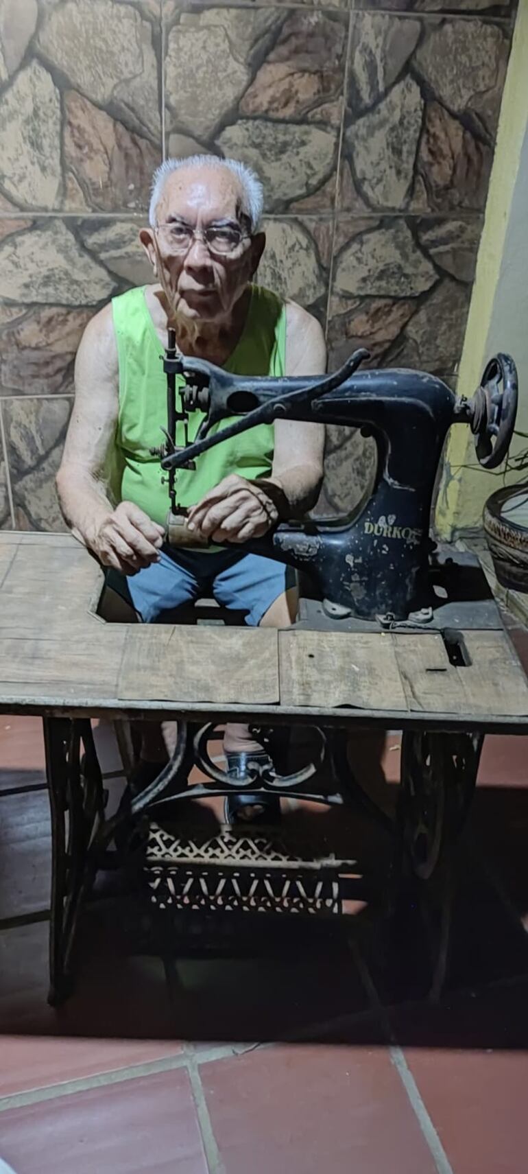 Don Basilides ante la vieja máquina de su taller de talabartería acunando recuerdos.