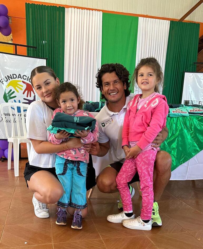 ¡Felices! Nelson Haedo Valdez con sus hijas Noemí y Leonie entregando un obsequio a una niña de San Joaquín. (Instagram/Nelson Haedo Valdez)