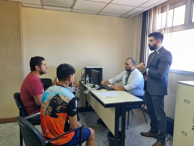 Rolando Zarza González y  Bruno Joel Jorgge Arriola (de remera bordó), sentados frente al juez Osmar Legal, quien está parado.