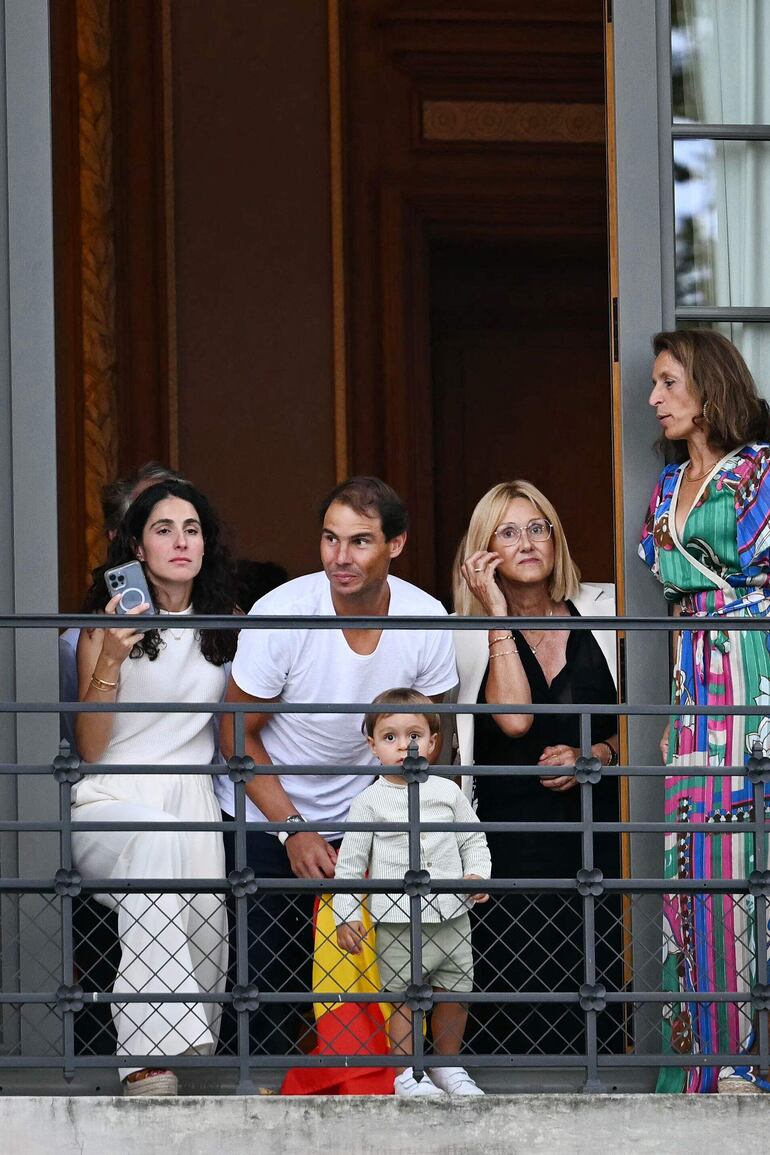 El tenista español Rafael Nadal, su madre Ana María Parera, su esposa María Francisca Perelló y su hijo Rafa Junior observan desde un balcón la ceremonia inaugural de los Juegos Olímpicos de París 2024.
(Manan VATSYAYANA / AFP)