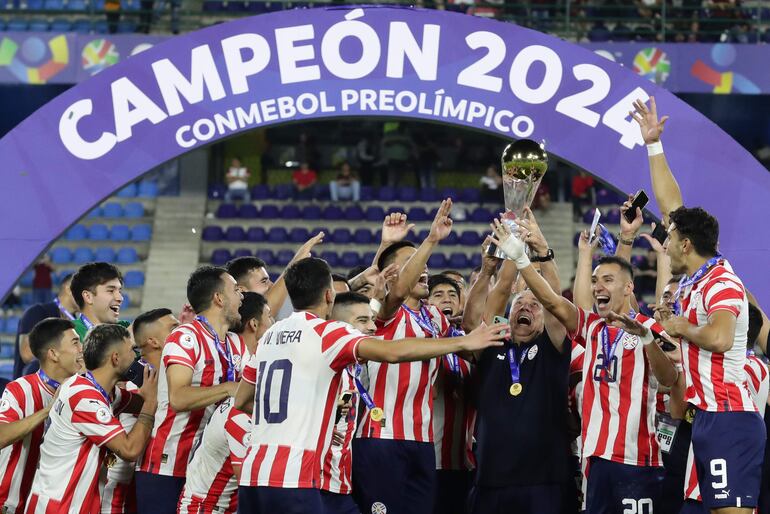 Los jugadores y el entrenador Carlos Jara Saguier (trofeo en mano) celebran la clasificación a Los Juegos Olímpicos París 2024 y la consagración de campeón del Preolímpico 2024 en el estadio Nacional Brígido Iriarte, en Caracas, Venezuela.