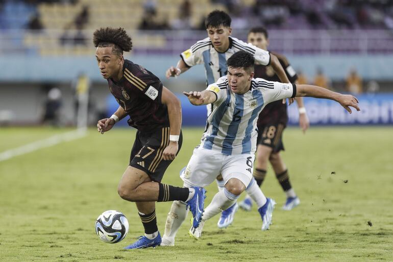 Eric Da Silva Moreira, de Alemania, domina el balón ante el argentino Juan Villalba, durante el partido que disputaron ayer en Surakarta por semifinales del Mundial Sub 17.