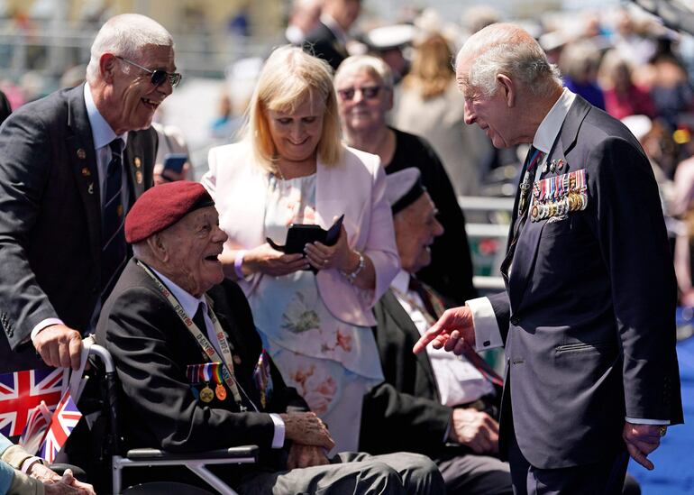 El rey Carlos III saluda al veterano del Día D Len Trewin, de 98 años, tras el evento conmemorativo nacional del Reino Unido para conmemorar el 80º aniversario del desembarco anfibio aliado (desembarco del Día D) en Francia en 1944, en Southsea Common, en el sur de Inglaterra.(Andrew Matthews / POOL / AFP)