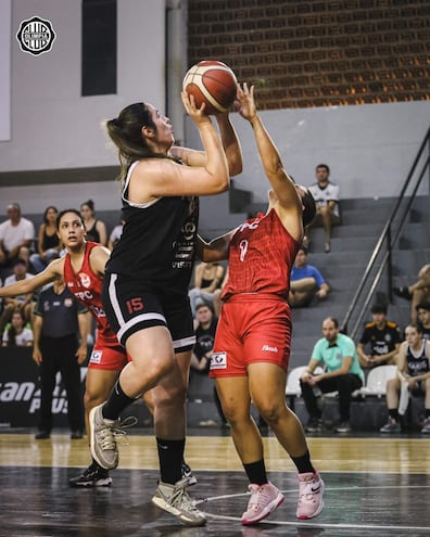 Adela Cárdenas pívot olimpista intenta lanzar ante la marca de la capitana “roja” Jazmín Mercado. Observa Ana Brítez (i).