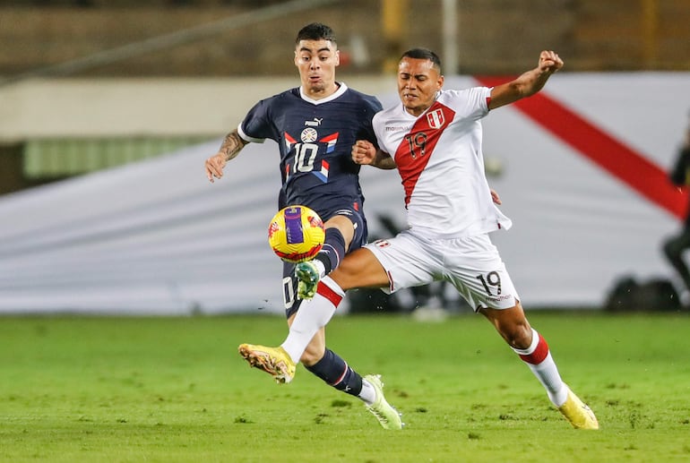 Bryan Reyna (d) de Perú disputa un balón con Miguel Almirón de Paraguay en un partido amistoso internacional entre las selecciones de Perú y Paraguay en el estadio Monumental de la U en Lima (Perú).