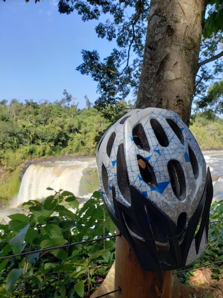 Un casco de bicicleta apoyado en un árbol del Parque Municipal Monday. De fondo los saltos epónimos.