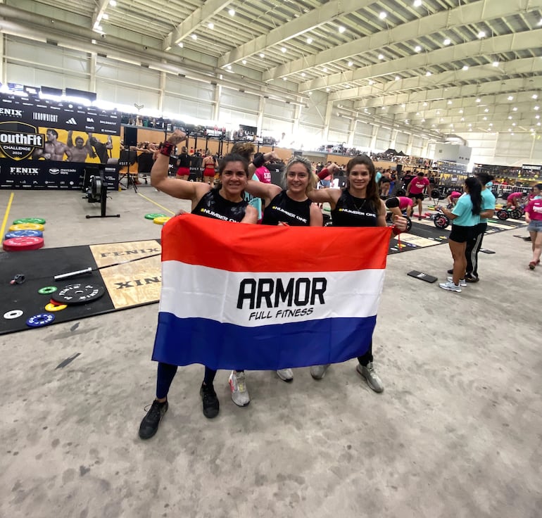 Con la infaltable bandera paraguaya, las compatriotas Leticia Robledo, Patricia Buena y Jessica Chávez, en la competencia SouthFit Challenge 2024, en Buenos Aires, Argentina.