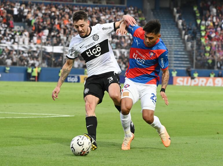 Alejandro Silva, jugador de Olimpia, y Santiago Arzamendia, futbolista de Cerro Porteño, pelean por el balón en el superclásico del fútbol paraguayo en el estadio La Nueva Olla por la sexta fecha del torneo Clausura 2023.