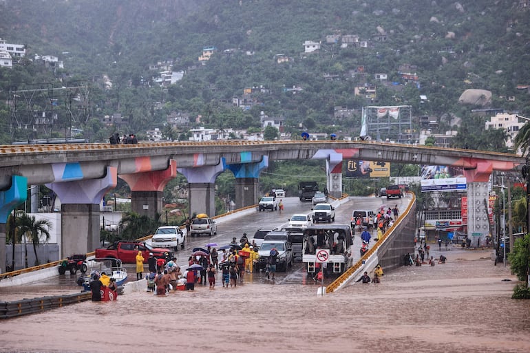 Fotografía de una avenida inundada por el paso del Huracán John en la parte alta del puerto de Acapulco, este viernes, en Guerrero (México). Las autoridades mexicanas reportaron este viernes otros 6 muertos por el huracán John, con lo que la cifra de fallecidos aumenta a 22, desde el impacto del ciclón el lunes pasado, de los que 18 son en el estado sureño de Guerrero, otros 3 en el vecino Oaxaca y uno más en Michoacán. EFE/ David Guzmán