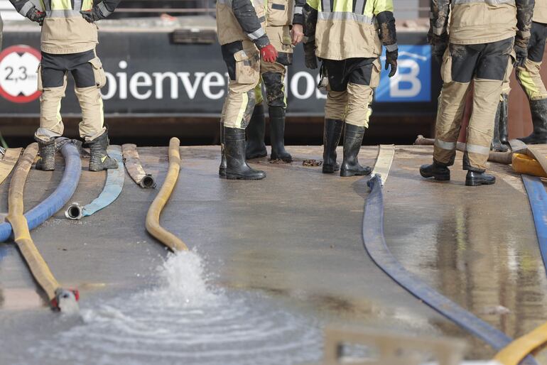 Bomberos extraen agua del un estacionamiento subterráneo en Valencia.