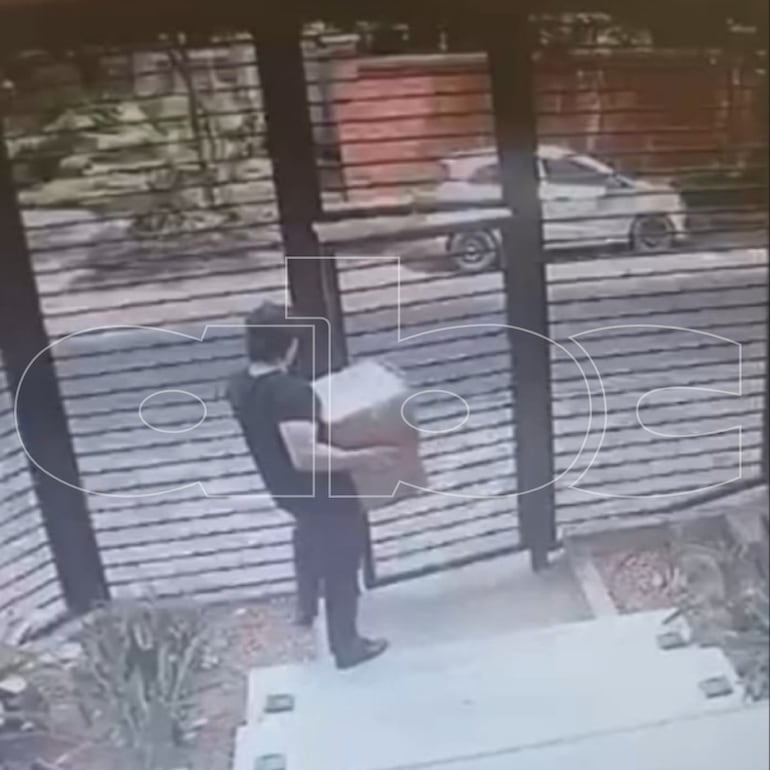 Momento en que un hombre, que sería el detenido, pretende salir del edificio de Villa Morra con cajas aparentemente cargadas con expedientes judiciales.