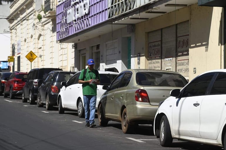 Empleado de Parxin verifica automóviles estacionados en el centro de Asunción.