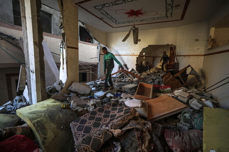 Dos hombres revisan los escombros de una casa dañada por un bombardeo israelí, el pasado jueves en Deir el Balah.
