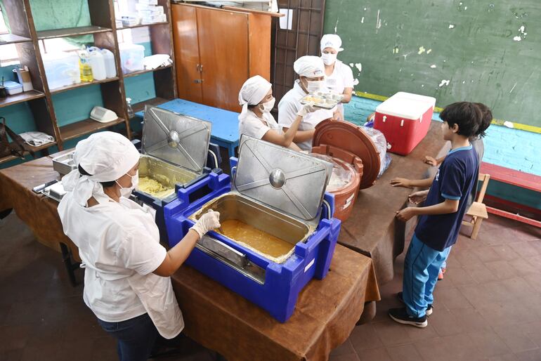 Niños recibiendo el almuerzo escolar de hoy, en la escuela Juan Pedro Escalada de Lambaré.