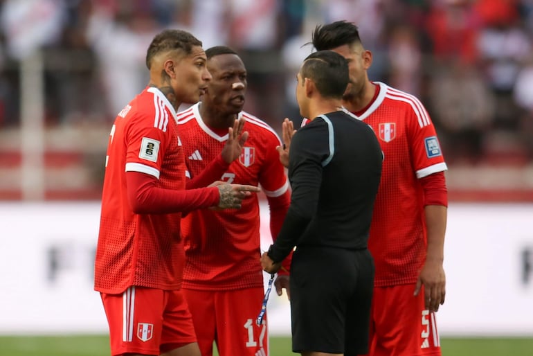 Paolo Guerrero (i) y Luis Advíncula (c), jugadores de Perú, reclaman al árbitro ecuatoriano Guillermo Guerrero en un partido de las Eliminatorias Sudamericanas 2026 en el estadio Hernando Siles, en La Paz.
