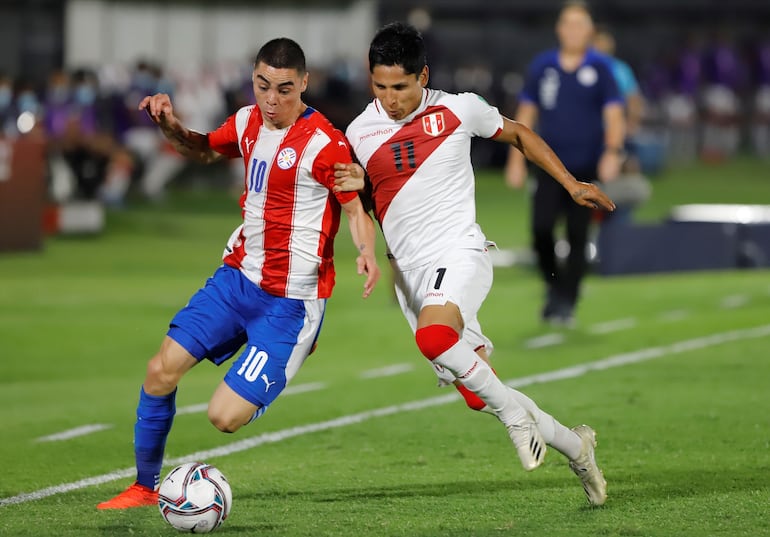 Raúl Ruidíaz (d), jugador de Perú, lucha por el balón con Miguel Almirón, futbolista de Paraguay, durante un partido de las Eliminatorias Sudamericanas al Mundial Qatar 2022 en el estadio Defensores del Chaco, en Asunción. 