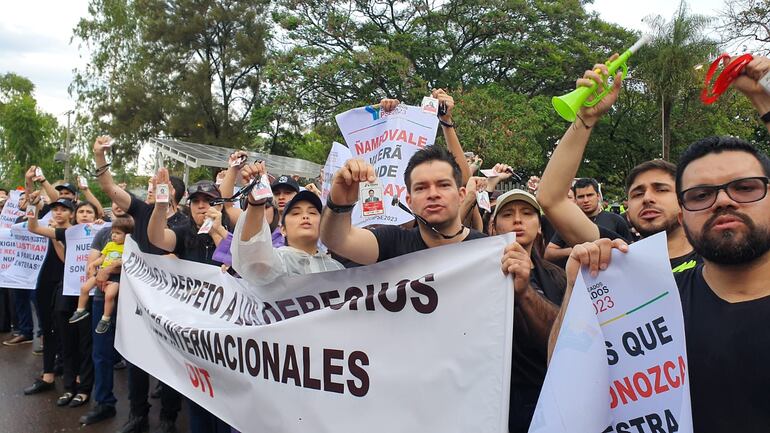 Los empleados descontratados muestran su credencial que ganaron en el concurso de Itaipú.