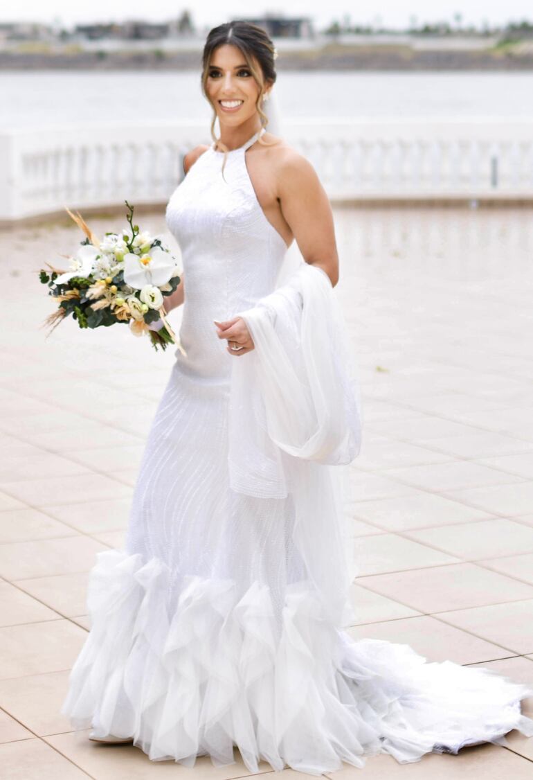 La novia lució un elegante vestido muy moderno confeccionado por Ocre. Los zapatos fueron de Olinda y fue maquillada por Claudio Ferreira, y peinada por Yonatan Chaparro. El tocado fue una creación de Liraló.