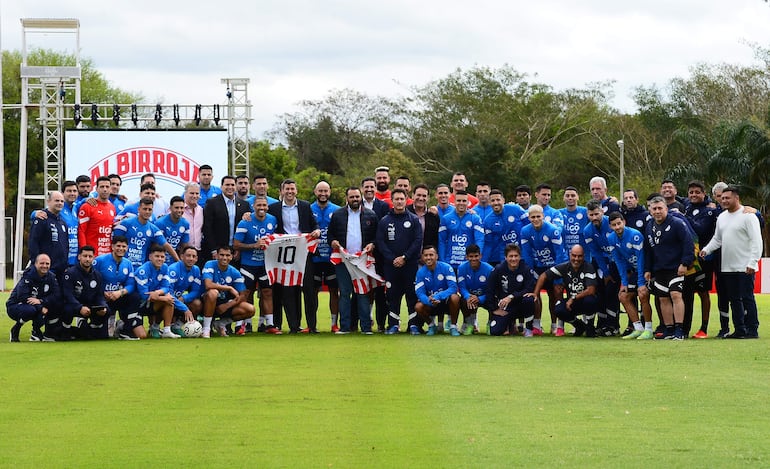 El presidente de Paraguay Santiago Peña (c-i) y el ministro de deportes de Paraguay Cesar Ramírez (c-d) posan con los jugadores de la selección paraguaya en el centro de entrenamiento CARDE, en Ypané, Paraguay.