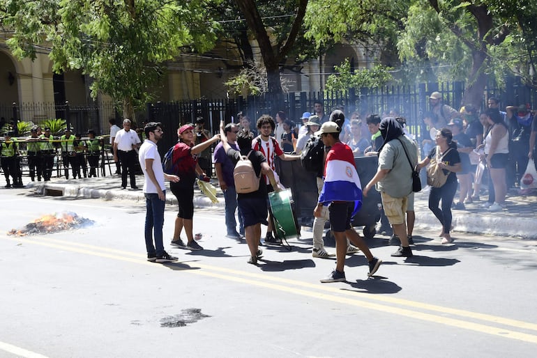 Universitarios momentos después de quemar algunos residuos frente al Parlamento Nacional, en reclamo por la falta de blindaje del Arancel Cero, con proyecto "Hambre cero".