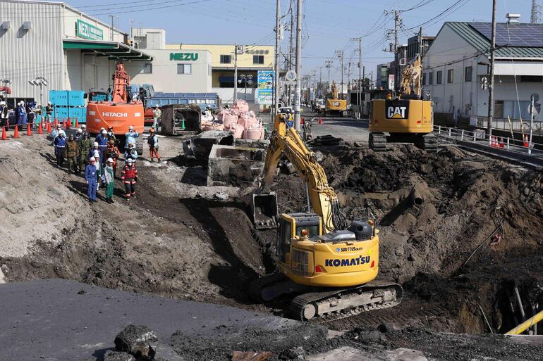 Excavadoras y personal de rescate trabajan para construir una pendiente para las operaciones de rescate en el lugar donde el 28 de enero un camión se hundió en un socavón, atrapando al conductor del vehículo, en Yashio, prefectura de Saitama, el 1 de febrero de 2025.