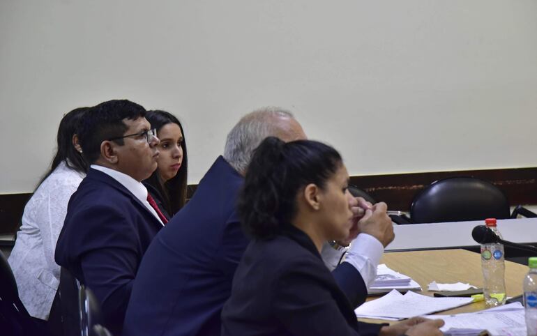 La agente policial Evelyng Núñez (izq.), con los abogados de la defensa, en la sala de juicio oral y público. 