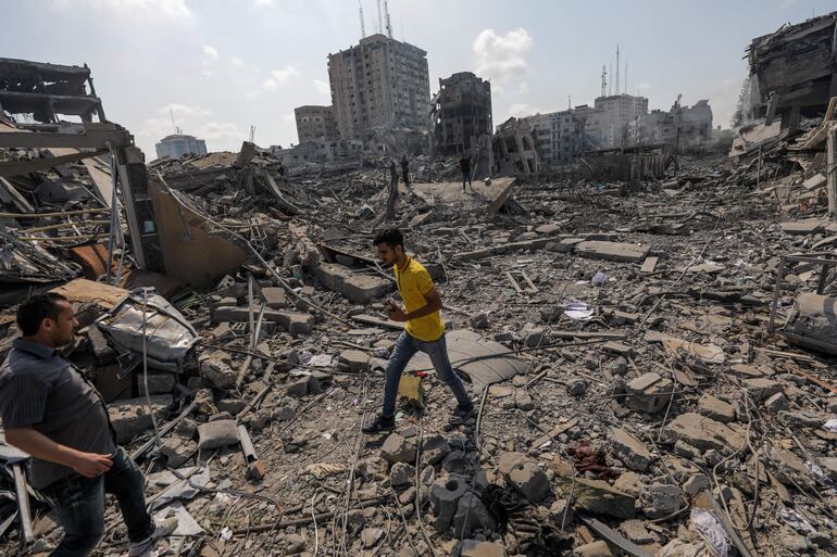 -FOTODELDÍA- GAZA, 10/10/2023.- Palestinos caminan entre los escombros tras un ataque a la zona de Al-Ramal, tras un ataque israelí, este martes en la Ciudad de Gaza. Más de 700 personas han muerto y alrededor de 4.000 han resultado heridas después de que Israel comenzara a bombardear Gaza como respuesta al ataque en suelo israelí del grupo islamista Hamas, según datos ofericos por las autoridades palestinas. En total más de 3000 personas han muerto en esta escalada de violencia desde el 7 de octubre, según fuentes palestinas e israelíes. EFE/MOHAMMED SABER
